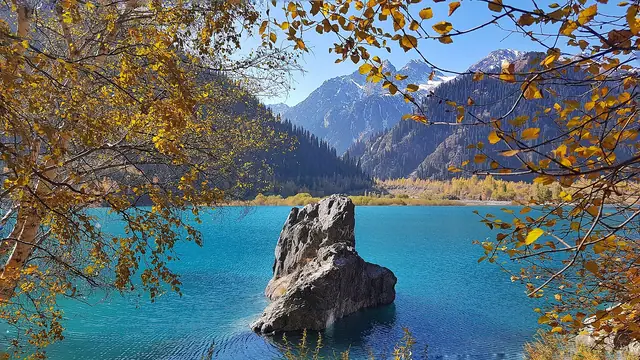 Есік көлі: күзгі жапырақ арасындағы көл мен жартас