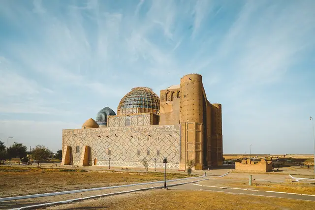 Turkestan: mausoleum of Khoja Ahmed Yasawi with its portal and turquoise domes under a wide sky