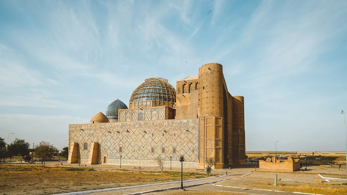 Turkestan: mausoleum of Khoja Ahmed Yasawi with its portal and turquoise domes under a wide sky